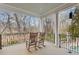 Covered porch with rocking chairs offers a serene view of the landscaped backyard and pond at 3977 Sweet Bottom Dr, Duluth, GA 30096