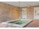 A stunning outdoor spa room boasts a chandelier, brick walls, and a tile in-ground spa at 3977 Sweet Bottom Dr, Duluth, GA 30096