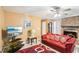 Inviting living room features a cozy fireplace, ceiling fan and comfortable red sofa with patterned pillows at 60 Mountain View Cir, Covington, GA 30016