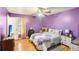 Main bedroom with wood floors, ceiling fan, and decorated in purple hues at 60 Mountain View Cir, Covington, GA 30016