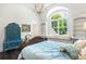 Elegant bedroom featuring a window seat, built-in shelves, and beautiful views of the surrounding greenery at 165 Ansley Way, Roswell, GA 30075