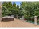 A spacious deck features an outdoor seating area and a wrought iron railing with views of lush greenery and the pool at 165 Ansley Way, Roswell, GA 30075