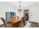 A stylish dining room with hardwood floors, a chandelier, seating for six and an access to the patio at 165 Ansley Way, Roswell, GA 30075