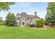 Charming brick home with lush front lawn, blue shutters, mature trees, and manicured landscaping at 165 Ansley Way, Roswell, GA 30075