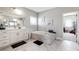 Bright bathroom featuring a soaking tub with marble tile surround, a double vanity, and tiled floors at 6375 Haystack Ct, Cumming, GA 30040