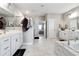 Spacious bathroom featuring dual sinks, a soaking tub, and a separate shower, all adorned with marble-like tile at 6375 Haystack Ct, Cumming, GA 30040