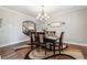 Elegant dining room with a stylish chandelier, hardwood floors, and ample natural light for formal gatherings at 6375 Haystack Ct, Cumming, GA 30040