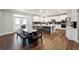 A modern kitchen featuring white cabinets, a spacious island, and a dining area at 6375 Haystack Ct, Cumming, GA 30040