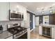 Well-lit kitchen features stainless steel appliances, gray countertops, white cabinetry and open access to laundry at 3186 Quail Ct, Decatur, GA 30034