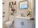 This bathroom features a white vanity with gold hardware, a black faucet, and modern geometric art at 1253 Lucile Sw Ave, Atlanta, GA 30310