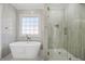 Bathroom featuring a modern shower, soaking tub, a window for natural light, and towel rack at 1253 Lucile Sw Ave, Atlanta, GA 30310