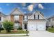 Charming two-story home featuring stone accents, a two-car garage, and a well-manicured lawn at 26 Crescent Ln, Dallas, GA 30157