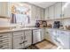 Bright kitchen featuring white cabinets, stainless steel appliances, and a view of the backyard through the window at 2951 N Mckoy Rd, Villa Rica, GA 30180