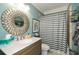 Stylish bathroom with a round mirror, decorative fixtures, and a shower with a patterned curtain at 624 Hemlock Trl, Canton, GA 30114