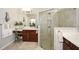 Modern bathroom featuring a glass-enclosed shower, granite countertops, and a vanity area with a chair at 624 Hemlock Trl, Canton, GA 30114