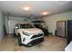 A well-lit garage with a car, golf cart, overhead storage, and metal storage cabinet at 624 Hemlock Trl, Canton, GA 30114