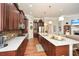 Open concept kitchen with island, white countertops, dark cabinets, and stainless steel appliances at 624 Hemlock Trl, Canton, GA 30114