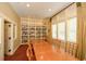 Well-lit library with a long wooden table surrounded by chairs, a bookshelf and several large windows at 624 Hemlock Trl, Canton, GA 30114