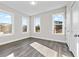 Bright bedroom featuring three large windows, neutral walls, and durable gray wood floors at 697 Fayetteville Rd # 303, Atlanta, GA 30316