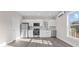 Bright and airy kitchen featuring white cabinetry, stainless steel appliances, and durable gray wood floors at 697 Fayetteville Rd # 303, Atlanta, GA 30316