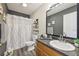 Well-lit bathroom with modern vanity, patterned shower curtain, and decorative shelving at 509 Chestnut Oak Dr, Palmetto, GA 30268