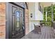 Close-up of the front door with stone accent, covered porch and seating area at 509 Chestnut Oak Dr, Palmetto, GA 30268