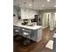 Modern kitchen with white cabinets, island with seating, stainless steel appliances, and hardwood floors offers functionality at 625 Huiet Dr, Mcdonough, GA 30252