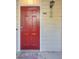 Close-up of a bold red front door with a modern keypad entry and a decorative exterior light fixture at 702 Spring Heights Se Ln # 7, Smyrna, GA 30080