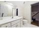 A bathroom featuring a white vanity, toilet, and patterned wallpaper at 120 Pine Mist Cir, Alpharetta, GA 30022