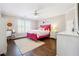 A bedroom with hardwood floors, a pink bed frame, and natural light from the window at 120 Pine Mist Cir, Alpharetta, GA 30022