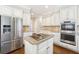 Bright kitchen featuring stainless steel appliances, a center island with a cooktop, and white cabinetry at 120 Pine Mist Cir, Alpharetta, GA 30022