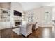 Cozy living room with stone fireplace, built-in shelves, hardwood floors, and large bright windows at 120 Pine Mist Cir, Alpharetta, GA 30022