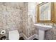 Powder room with decorative wallpaper, dark floor and pedestal sink at 120 Pine Mist Cir, Alpharetta, GA 30022