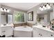 Bright bathroom featuring a large soaking tub, dual vanities, and natural light at 1252 Highfield Dr, Lawrenceville, GA 30043