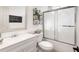 Bright bathroom with white vanity, frosted glass shower doors, and decorative shelving at 1252 Highfield Dr, Lawrenceville, GA 30043