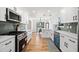 Bright, open kitchen featuring stainless steel appliances, a sleek backsplash, and hardwood floors at 1891 W Forrest Ave, Atlanta, GA 30344