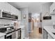 A view of a condo kitchen featuring white cabinets, stainless steel appliances, and wood-look flooring at 3655 Habersham Ne Rd # B148, Atlanta, GA 30305