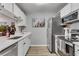 A bright condo kitchen featuring white cabinets, stainless steel appliances, and wood-look flooring at 3655 Habersham Ne Rd # B148, Atlanta, GA 30305