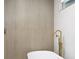 Modern bathroom featuring light wood grain-look tiling, gold fixtures, and a large soaking tub at 1120 Taliwa Ne Trl, Marietta, GA 30068
