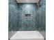 A stylish bathroom featuring blue herringbone tile with a niche and gold hardware at 1120 Taliwa Ne Trl, Marietta, GA 30068