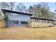 Home exterior view showcases a large wooden deck, grey exterior, and attached garage at 1120 Taliwa Ne Trl, Marietta, GA 30068