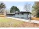 Exterior of this home features a grey exterior, large yard, and concrete driveway at 1120 Taliwa Ne Trl, Marietta, GA 30068