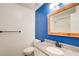 Stylish bathroom featuring a granite countertop vanity, wood-framed mirror, and a blue accent wall at 170 Roberts Rd, Covington, GA 30016