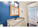 Bathroom features a granite countertop vanity, wood-framed mirror, and access to another room at 170 Roberts Rd, Covington, GA 30016