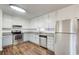 Well-lit kitchen with stainless steel appliances, white cabinets, and durable wood-look floors at 170 Roberts Rd, Covington, GA 30016