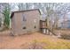 Exterior view of the rear of the house, showing the windows and wooded backyard at 123 Williamsburg Ln, Woodstock, GA 30189