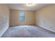 A bedroom with beige walls, carpet and a window bringing in natural light at 123 Williamsburg Ln, Woodstock, GA 30189