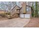 Charming home featuring a two-car garage, a wooded yard, and stairs to the front entrance at 123 Williamsburg Ln, Woodstock, GA 30189