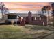 Beautiful backyard view of the brick home showing the screened porch, deck, and well-maintained lawn at 211 Garden W Walk, Hampton, GA 30228