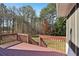 Back deck with railings overlooking a backyard with sparse trees, and a grassy yard at 211 Garden W Walk, Hampton, GA 30228